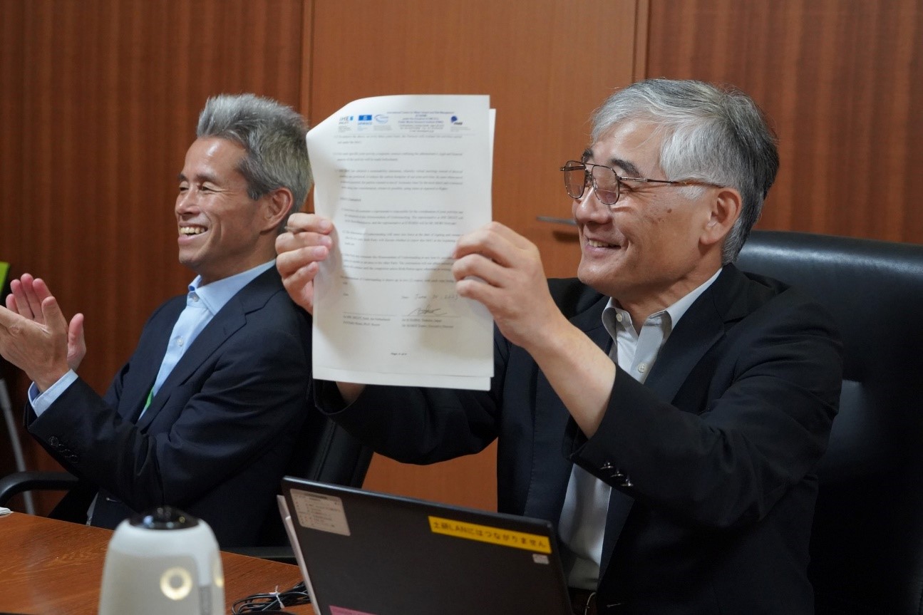 Exective Director Koike (right) confirming signatures through the screen