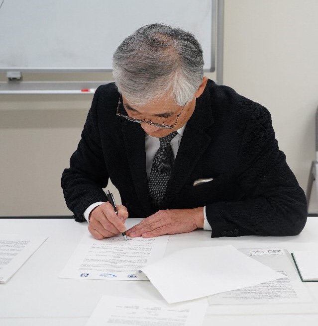 Executive Director Koike signs the MoU.